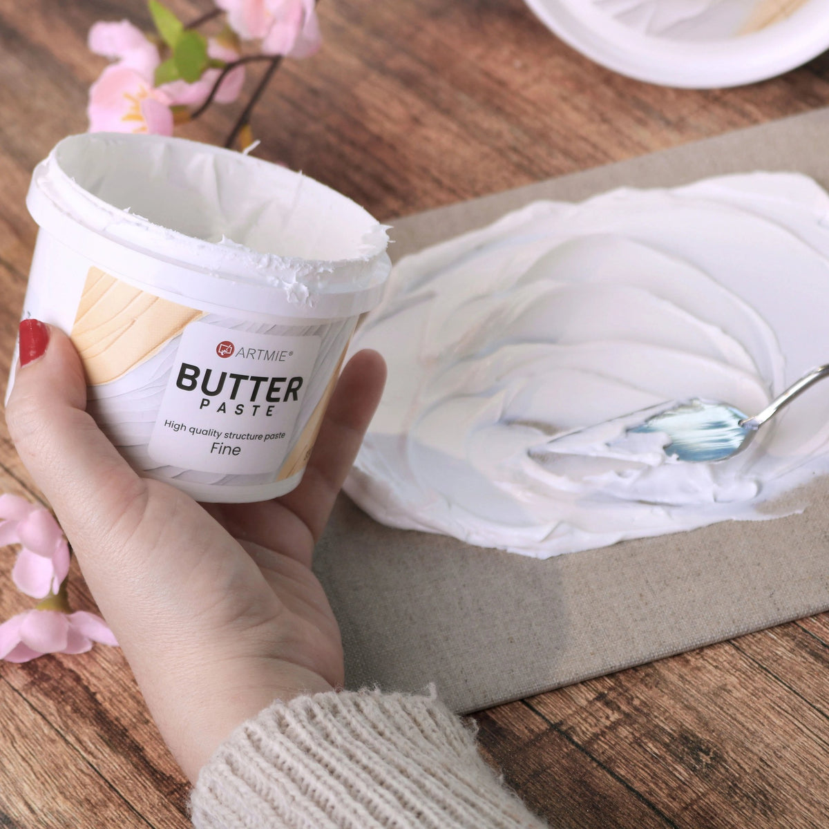 Отворена кутија и слој паста ARTMIE Butter Fine нанесен на платно со шпатула