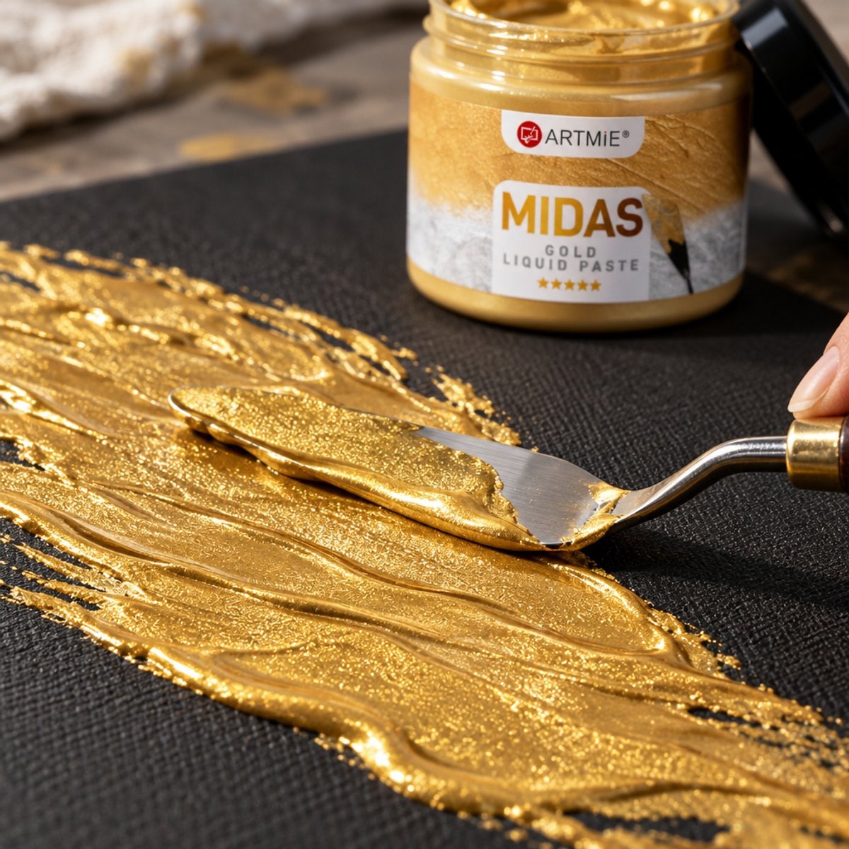 Нанесување златна метална паста ARTMIE MIDAS со шпатула на црно платно — макро